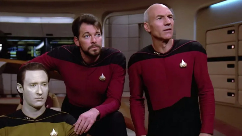 Data (Brent Spiner), Riker (Jonathan Frakes), and Picard (Patrick Stewart) look at the viewscreen in shock in Star Trek: The Next Generation