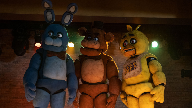 Freddy, Bonnie, and Chica in front of stage lights in Five Nights at Freddy's (2023)