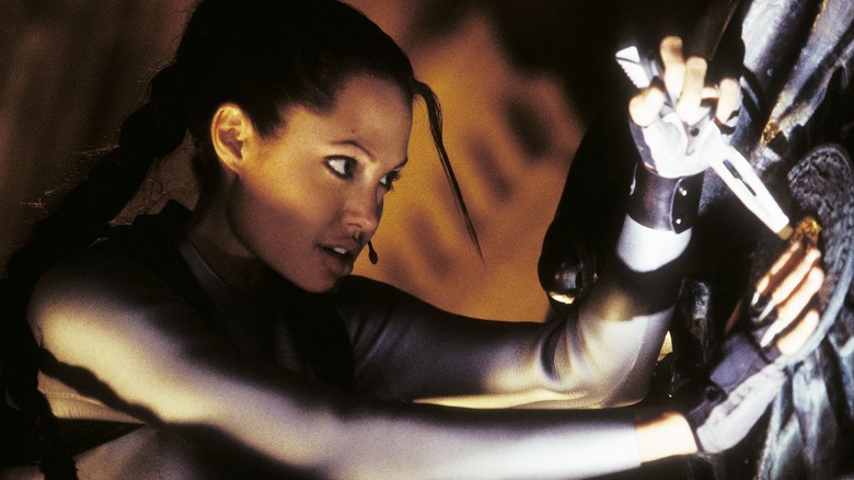 Lara Croft stealing a gold coin in Lara Croft: Tomb Raider – The Cradle of Life (2003)