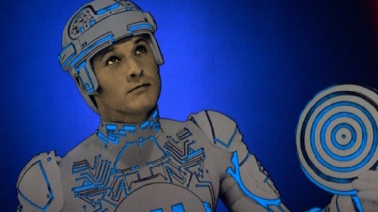 Tron holds his data disc, which is not a euphemism.