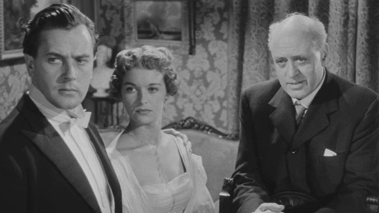 Brian Worth as Gerald, Eileen Moore as Sheila, and Alastair Sim as Poole, exploring a crime in An Inspector Calls