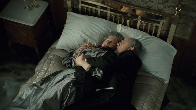Elderly couple holding each other on bed in Titanic