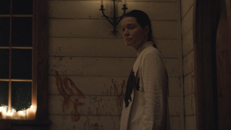 A bloody Bev Keane (Samantha Sloyan) in Midnight Mass standing outside a blood-streaked church