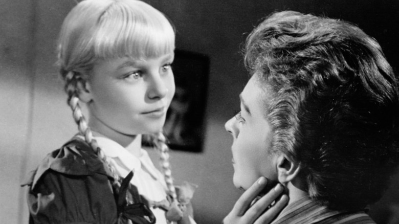 Patty McCormack as Rhoda in The Bad Seed strokes the chin of her mother Christine (Nancy Kelly)