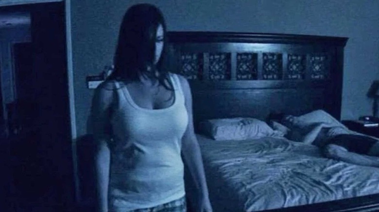 Young woman stands ominously