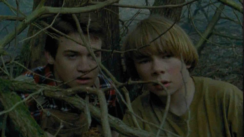 Grady Tucker (Brendan Fletcher) and Will Blake (Michael Barry) peer through tree branches in Goosebumps (1995)