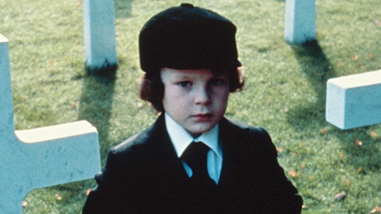 damien standing in graveyard