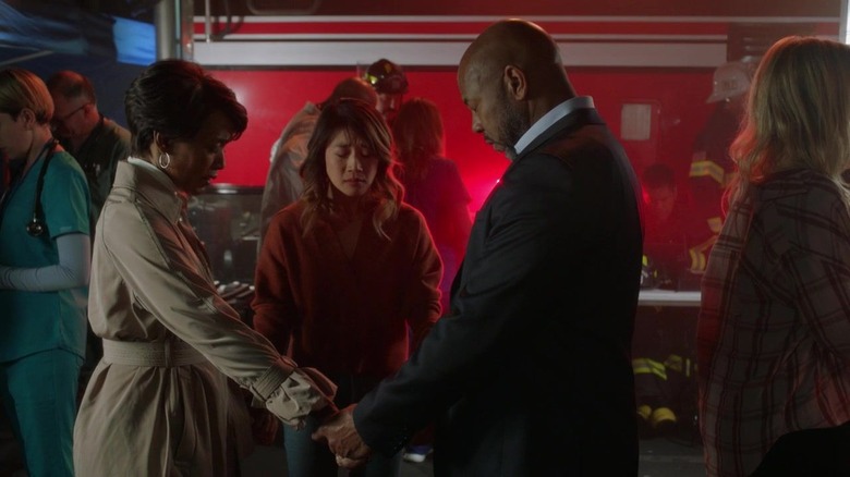 Athena, Michael and another woman holding hands