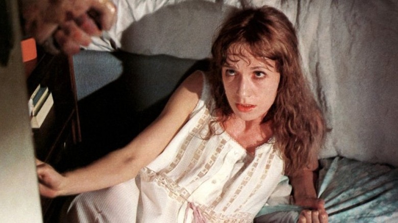 Daria Nicolodi sits on the floor, looking up terrified in Shock
