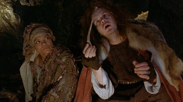 Freya looks on as Erik holds up an object
