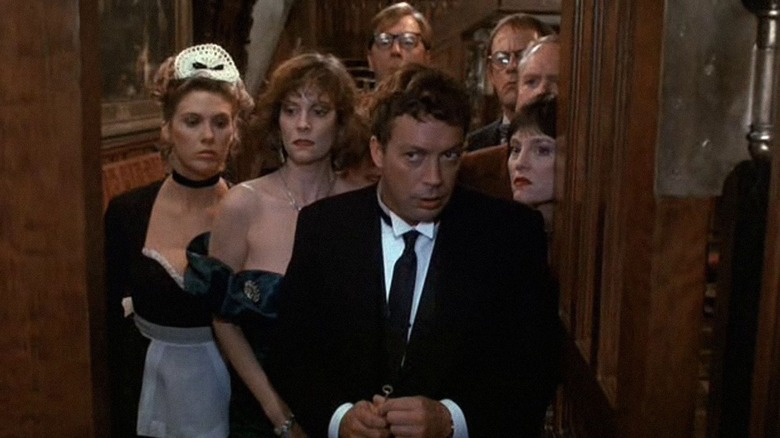 Cast of Clue standing suspiciously in doorway