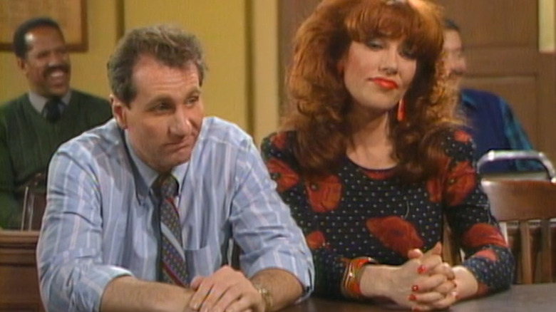 Al Bundy (Ed O'Neill) and Peggy Bundy (Katey Sagal) sit dejectedly at a table in Married... with Children