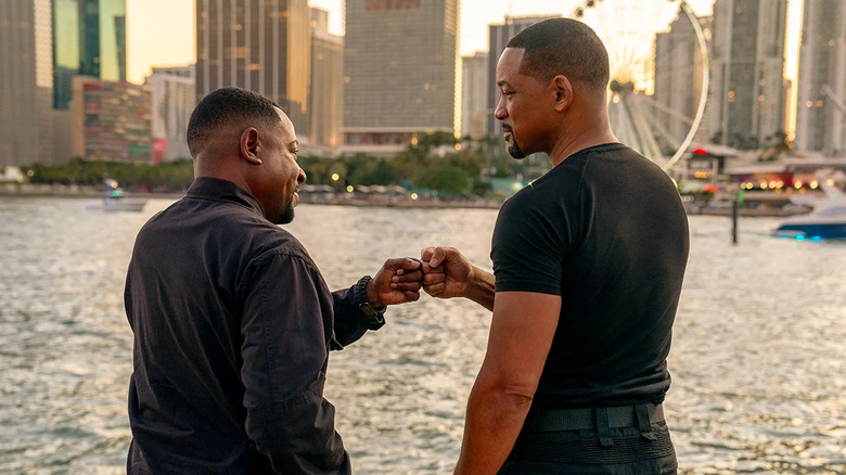 Martin Lawrence and Will Smith as Marcus Burnett and Mike Lowery, fist bumping by the water in Bad Boys: Ride or Die