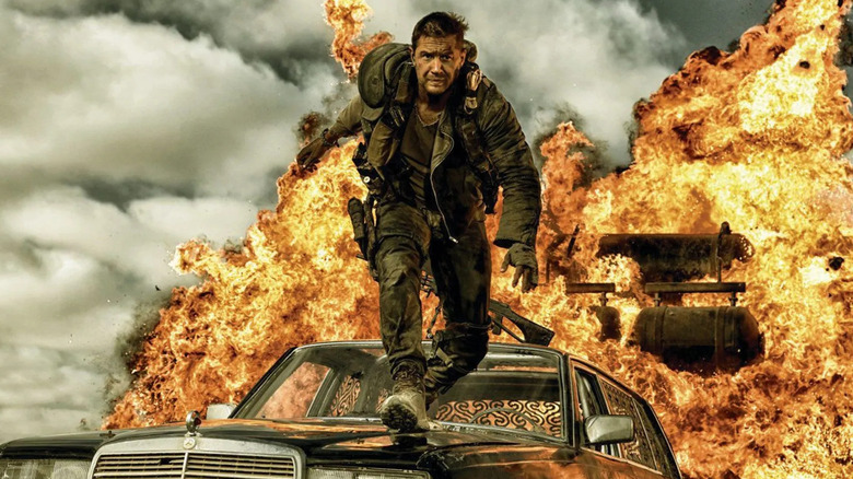 Tom Hardy as Max Rockatansky, walking on a car through fire in Mad Max: Fury Road
