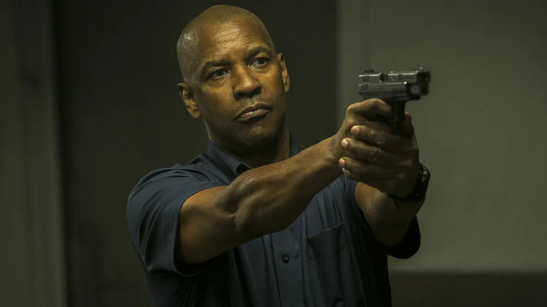 Denzel Washington as Robert McCall, aiming a pistol in The Equalizer