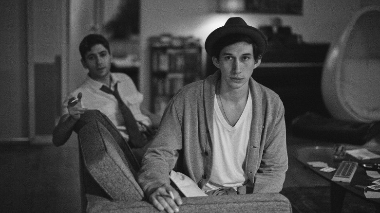 Adam Driver as Lev sitting on couch
