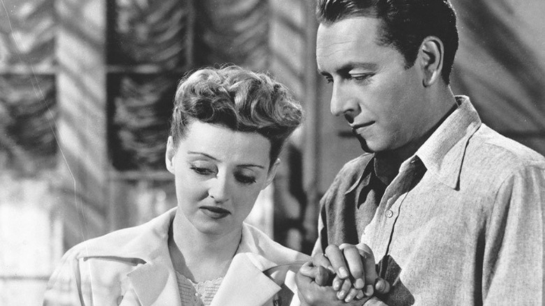 Bette Davis and Paul Henreid holding hands