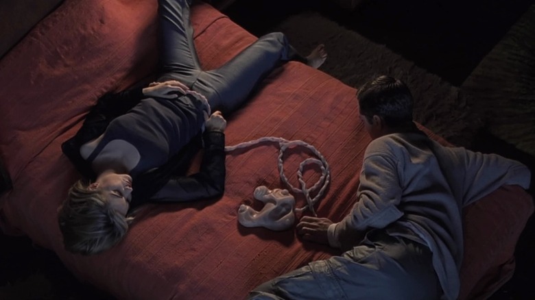 Jude Law and Jennifer Jason Leigh lay on bed in Crash