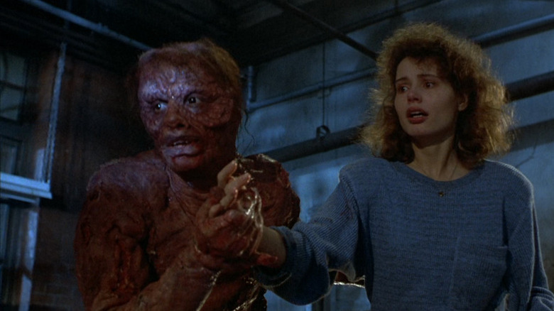 Geena Davis holds hands with the Brundlefly