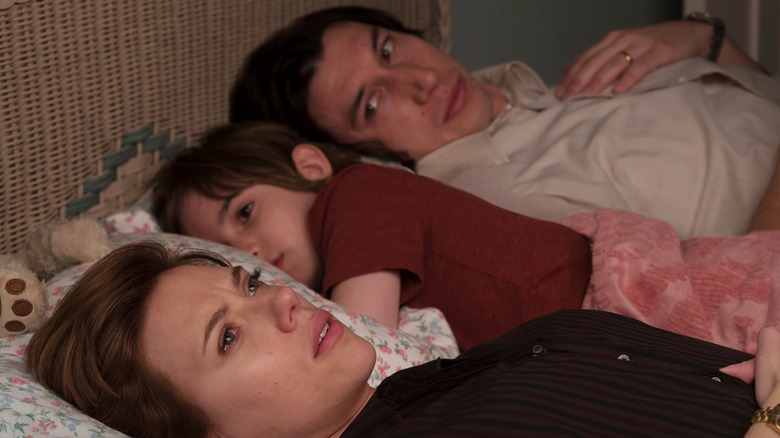 Scarlett Johansson as Nicole lying in bed with Azhy Robertson as Henry and Adam Driver as Charlie in Marriage Story