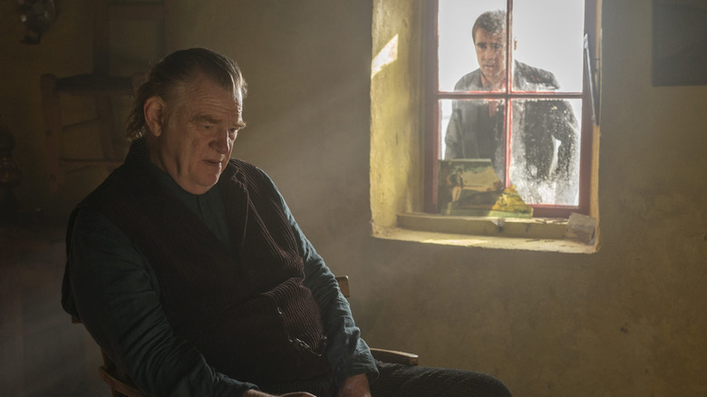 Colin Farrell as Pádraic looking at Brendan Gleeson as Colm through a window in The Banshees of Inisherin