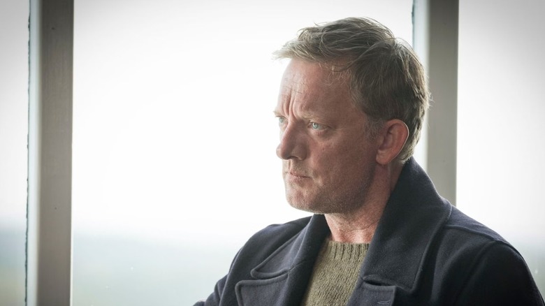 Jimmy Pérez (Douglas Henshall) sits stoically by a window in Shetland