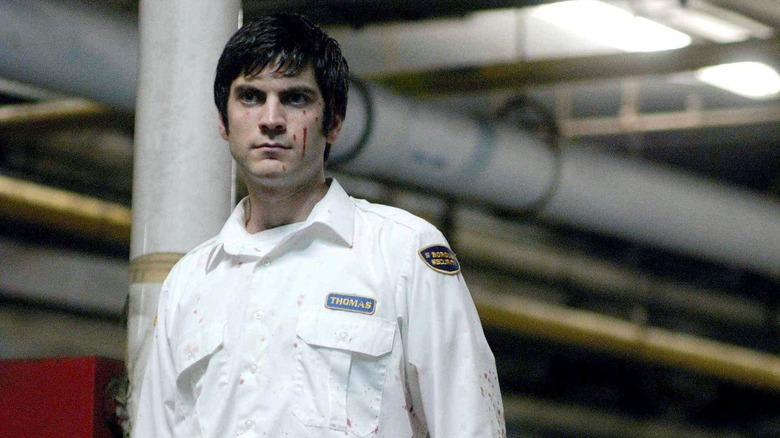 Thomas stands in garage in security uniform