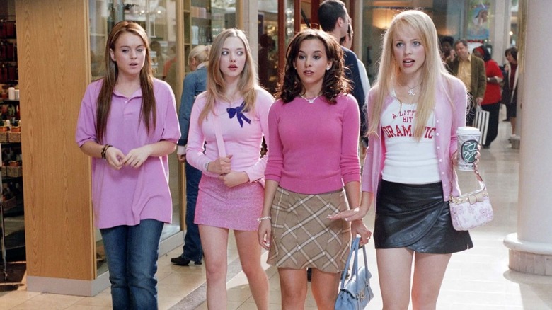 Lindsay Lohan as Cady Heron walks with Amanda Seyfried as Karen Smith, Lacey Chabert as Gretchen Wieners, and Rachel McAdams as Regina George in Mean Girls