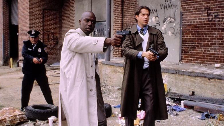 Frank Pembleton (Andre Braugher) and Tim Bayliss (Kyle Secor) draw guns at a crime scene in Homicide: Life on the Street