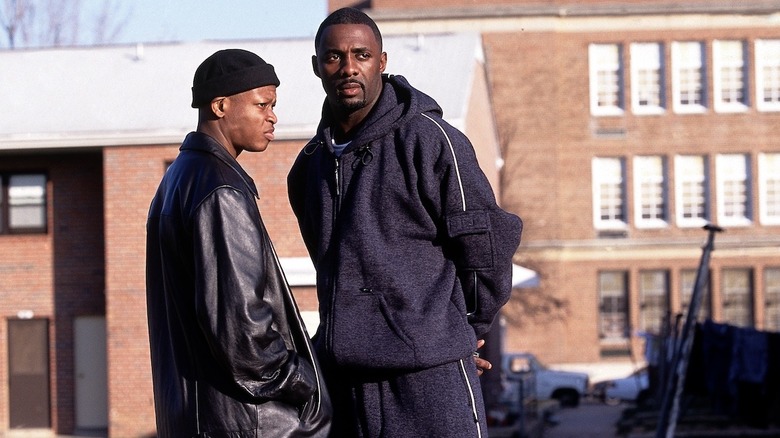D'Angelo Barksdale (Lawrence Gilliard, Jr.) and Stringer Bell (Idris Elba) stand close together by the projects in The Wire