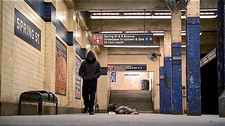 A hood man walks away from a corpse on a subway platform on Criminal Minds