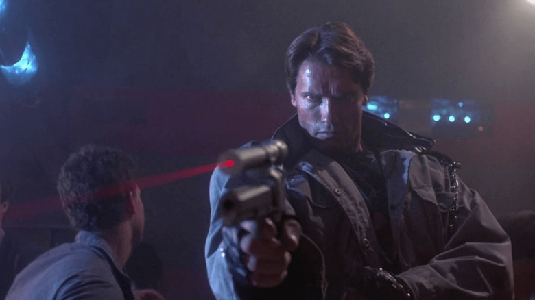 The T-800 (Arnold Schwarzenegger) aims the laser sight of his pistol in a nightclub in The Terminator