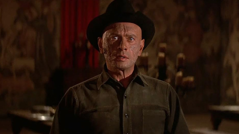 The gunslinger (Yul Brynner) looks burned in a dining room in Westworld