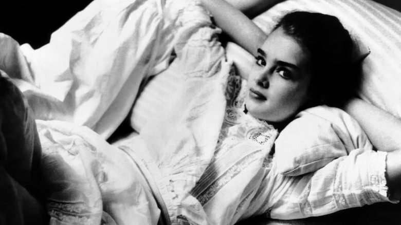 Young Brooke Shields reclining on bed in Pretty Baby