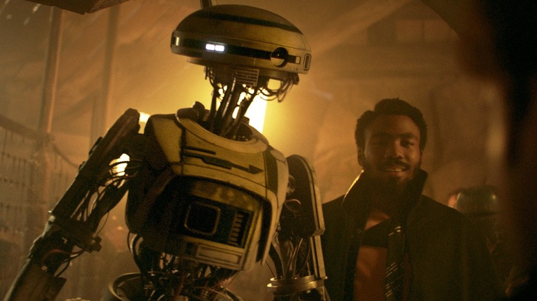 L3-37 in a dusty room with her best friend, Lando (Donald Glover) in Solo: A Star Wars Story