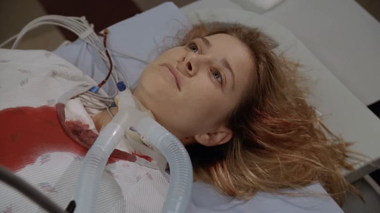 Kellie Martin as Lucy lying with blood on gown and tube in throat in ER