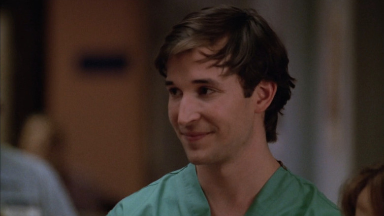 Noah Wyle as Carter smiling in green scrubs in ER