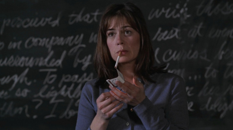 Maura Tierney as Abby Lockhart smoking cigarette in front of blackboard in ER