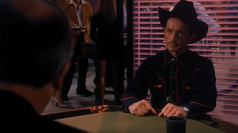 Reno sits at poker table in Cutting Cards