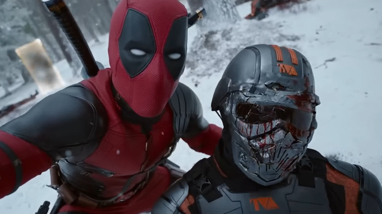 Deadpool (Ryan Reynolds) posing with dead TVA agent in Deadpool & Wolverine