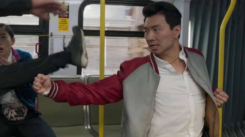 Shang-Chi (Simu Liu) punching a bad guy in Shang-Chi and the Legend of the Ten Rings