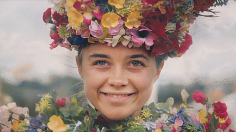 A woman covered in flowers smiles
