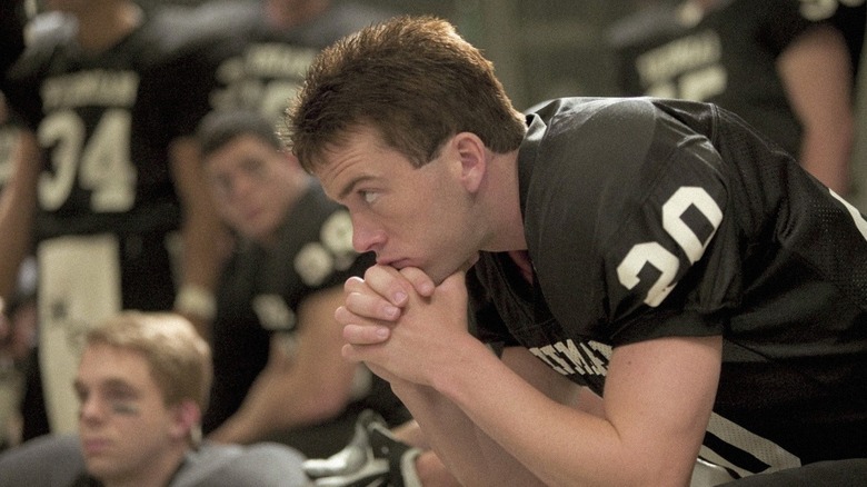 Mike Winchell (Lucas Black) sits on a bench intently in Friday Night Lights