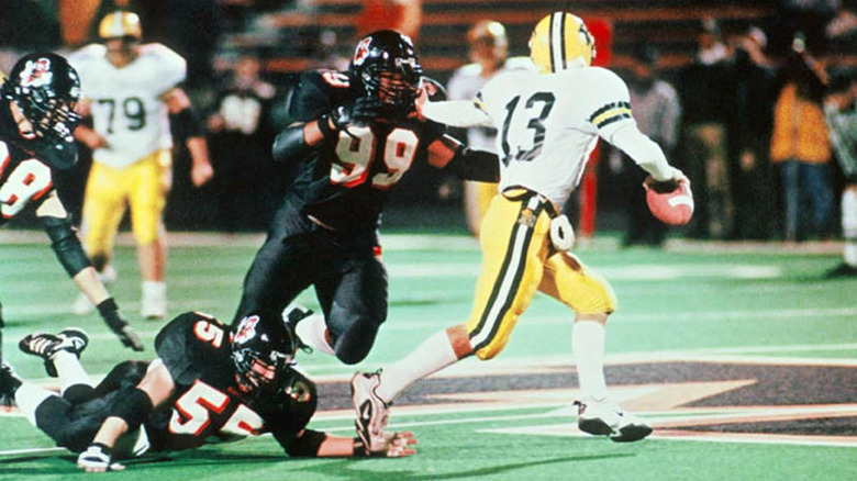 A high schooler running with a football evades the defense in Go Tigers!