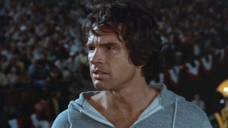 Joe Pendleton (Warren Beatty) stands on the sidelines in a hoodie in Heaven Can Wait (1978)