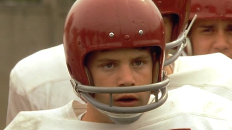 Rudy Ruettiger (Sean Astin) stands in disbelief in football training gear in Rudy