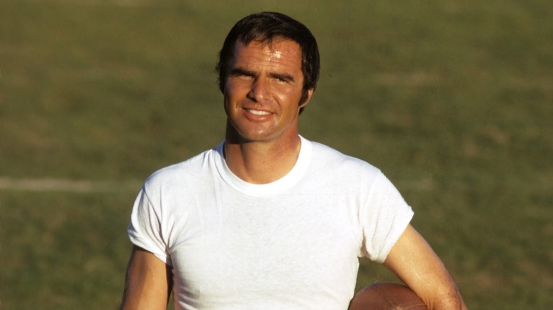 Paul Crewe (Burt Reynolds) stands sweaty and smiling on a football field in The Longest Yard (1974)