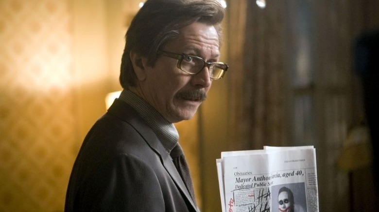 The Dark Knight Trilogy Gordon holding up paper