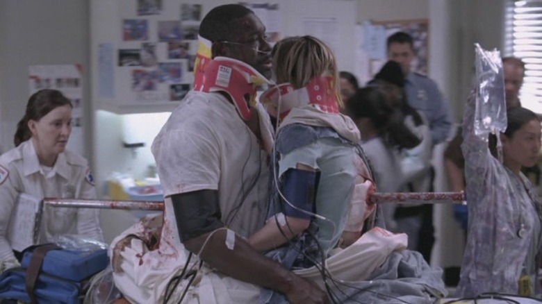 Monica Keena as Bonnie Crasnoff and Bruce A. Young as Tom Maynard sitting face to face on a gurney while impaled by the same metal pole on Grey's Anatomy