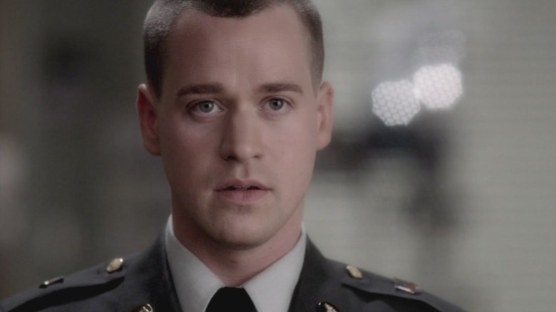 T. R. Knight as Dr. George O'Malley in an army uniform with a stunned expression on Grey's Anatomy